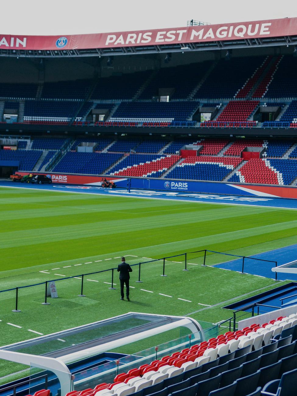 Pelouse et tribunes d'un grand stade de football vues depuis les gradins